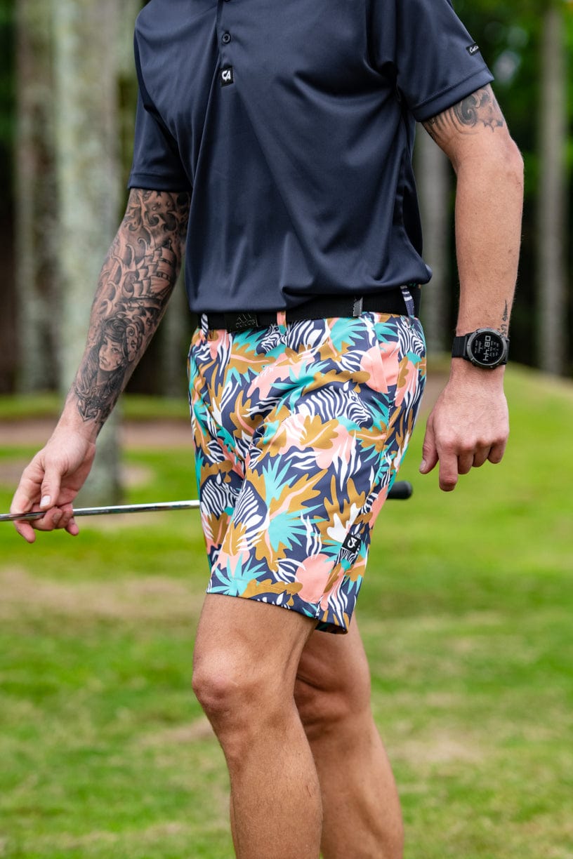 Tropical print golf shorts with a floral and leaf design, featuring stretch fabric for comfort.